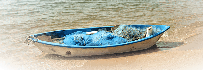 kleines fischerboot am strand mit netz